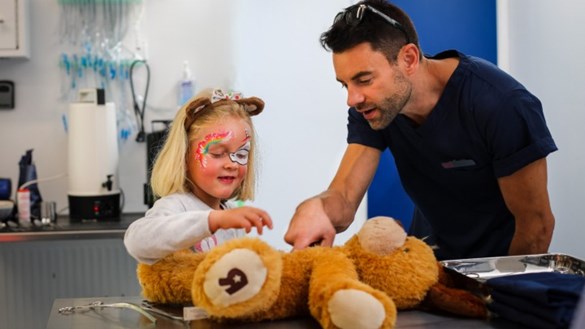 child with toy animal at vet