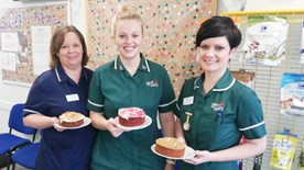 Staff showing off their baked cakes